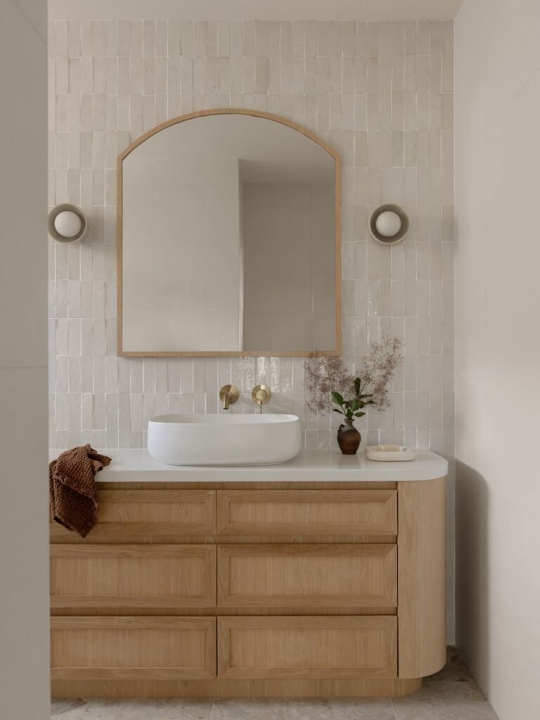 masterfuly designed bathroom with light wood vanity and tiles